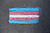 Trans-Pride-Flagge mit blauen, rosa und weißen Streifen auf Asphalt